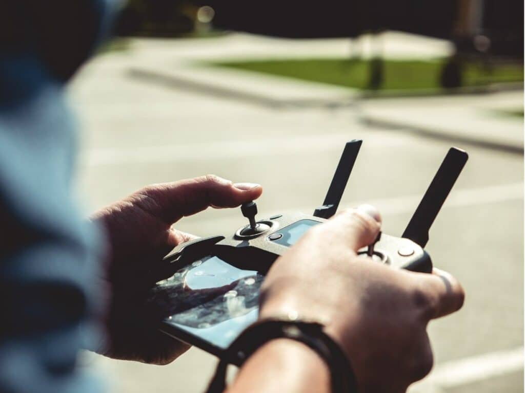 homme pilotant un drone avec une manette